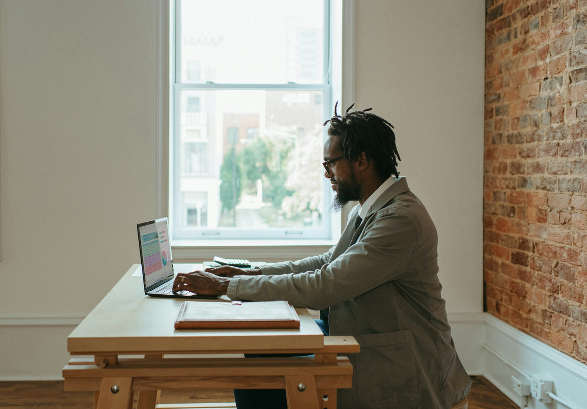 Person working at a desk with a laptop and papers